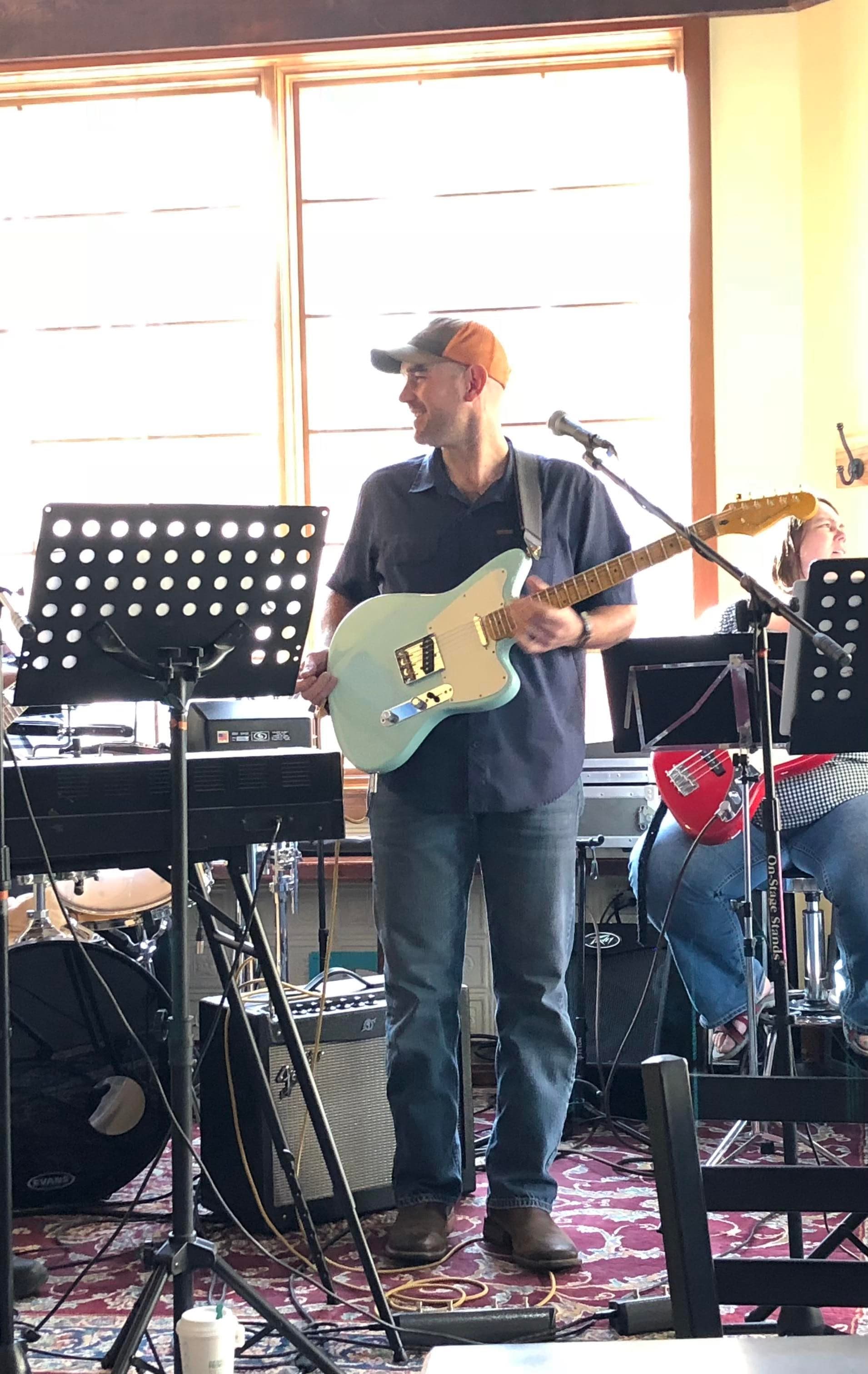Jon performing on stage with a Mountain Ash guitar